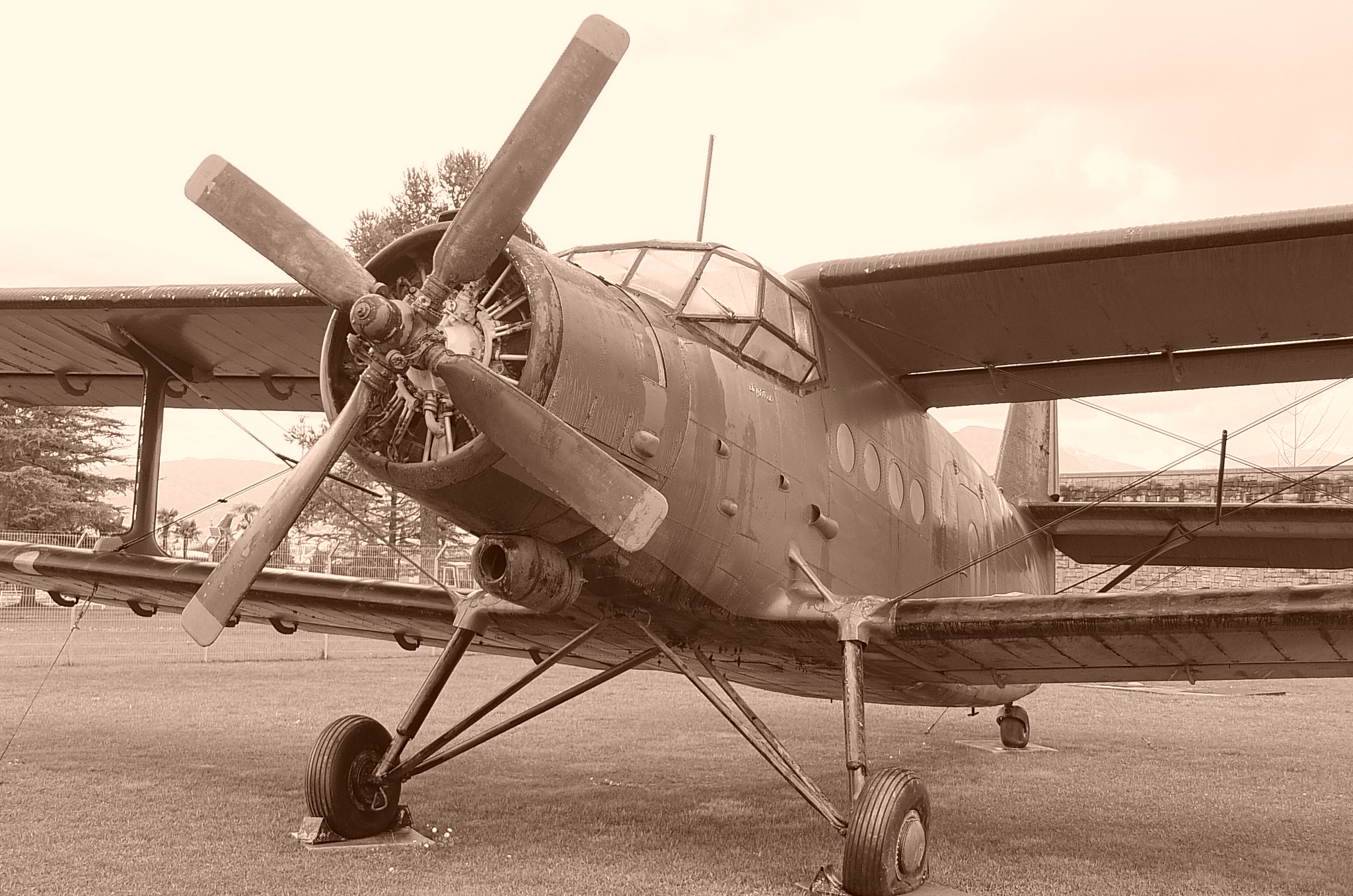 A black and white image of a vintage propeller aircraft on a runway