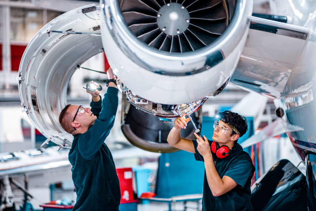 Two maintenance engineers inspecting a jet engine - replacement aircraft fasteners